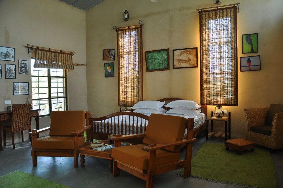 Guest room with a double bed, cane armchairs and framed prints