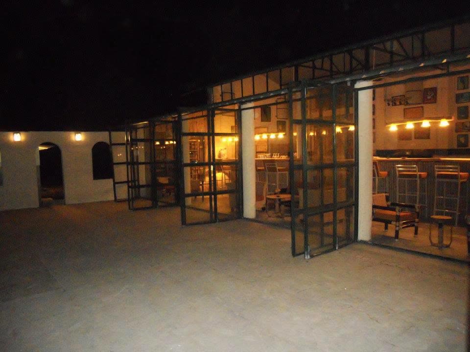 Glass-fronted dining pavilion glowing after dark