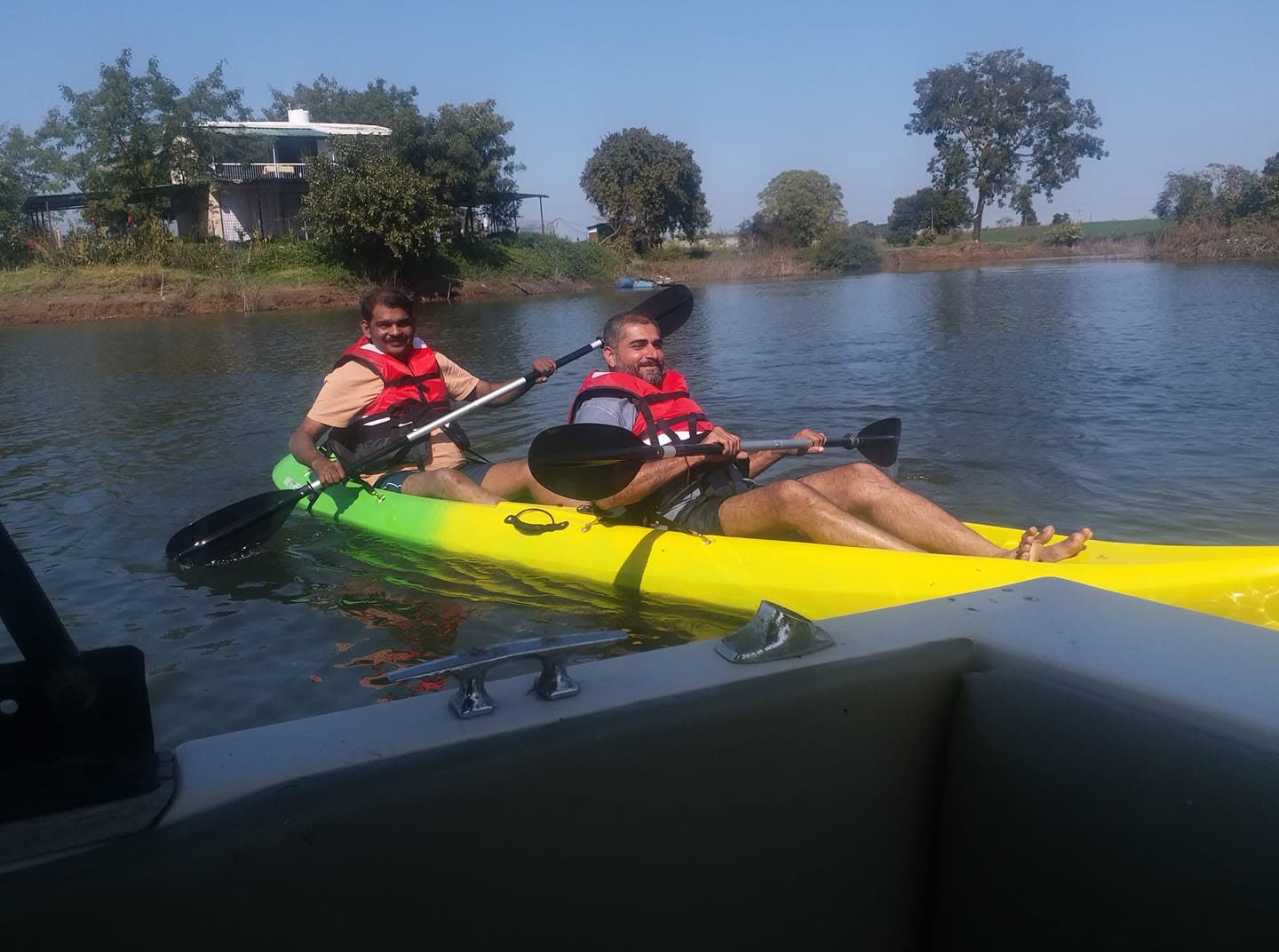 Two guests kayaking along the reedy shoreline