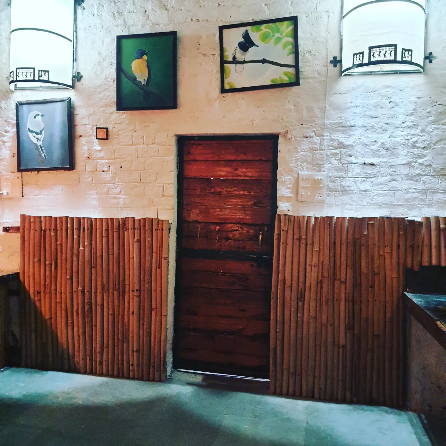 Carved wooden door with framed botanical prints