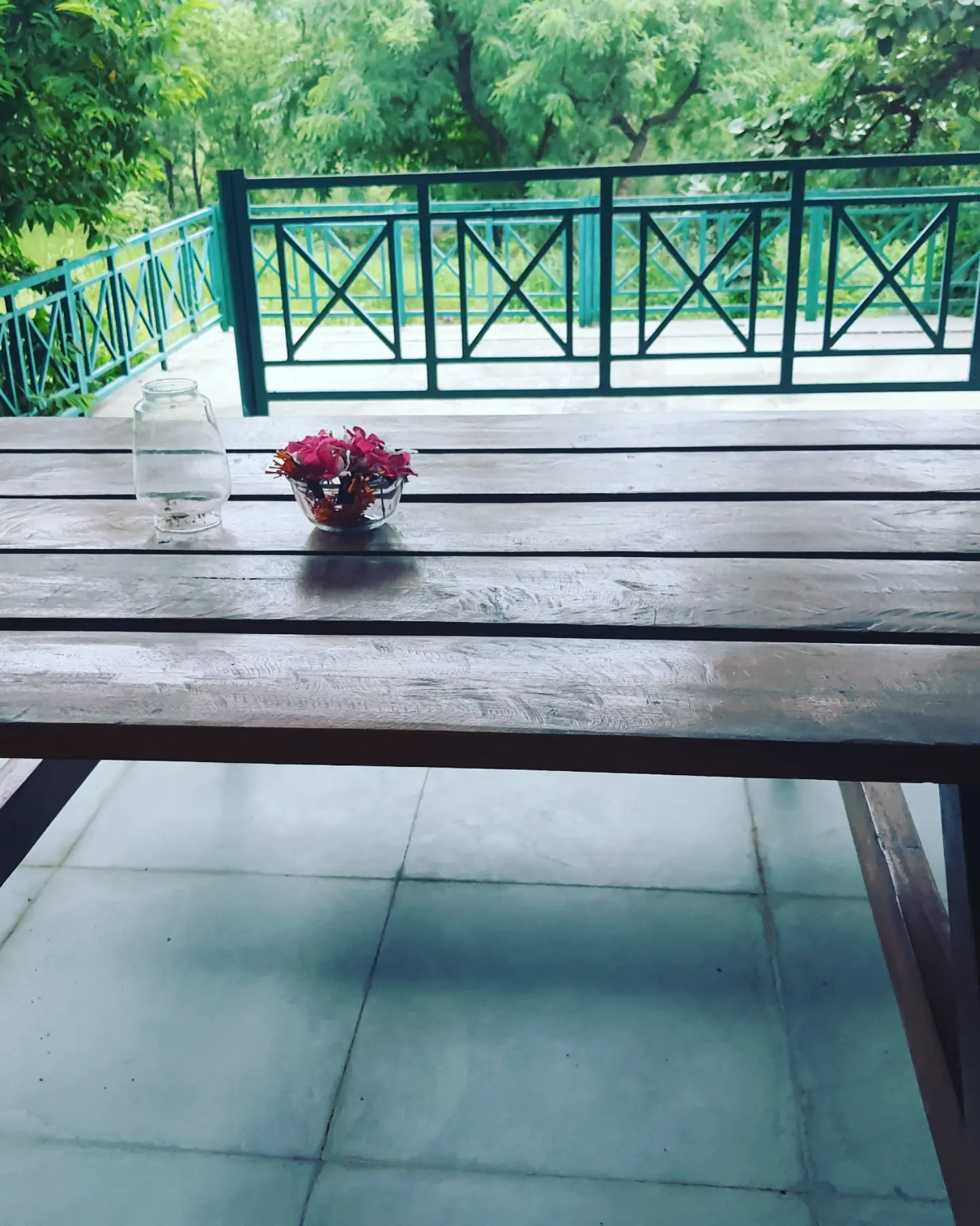 Wooden table set with fresh flowers on the terrace