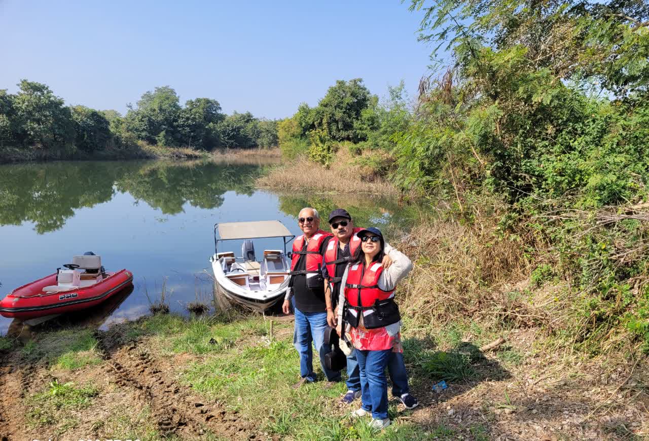 Guests in life jackets beside boats on a still backwater