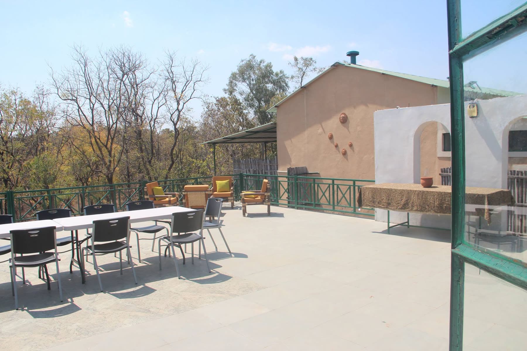 Dining tables set out on the open forest-facing terrace